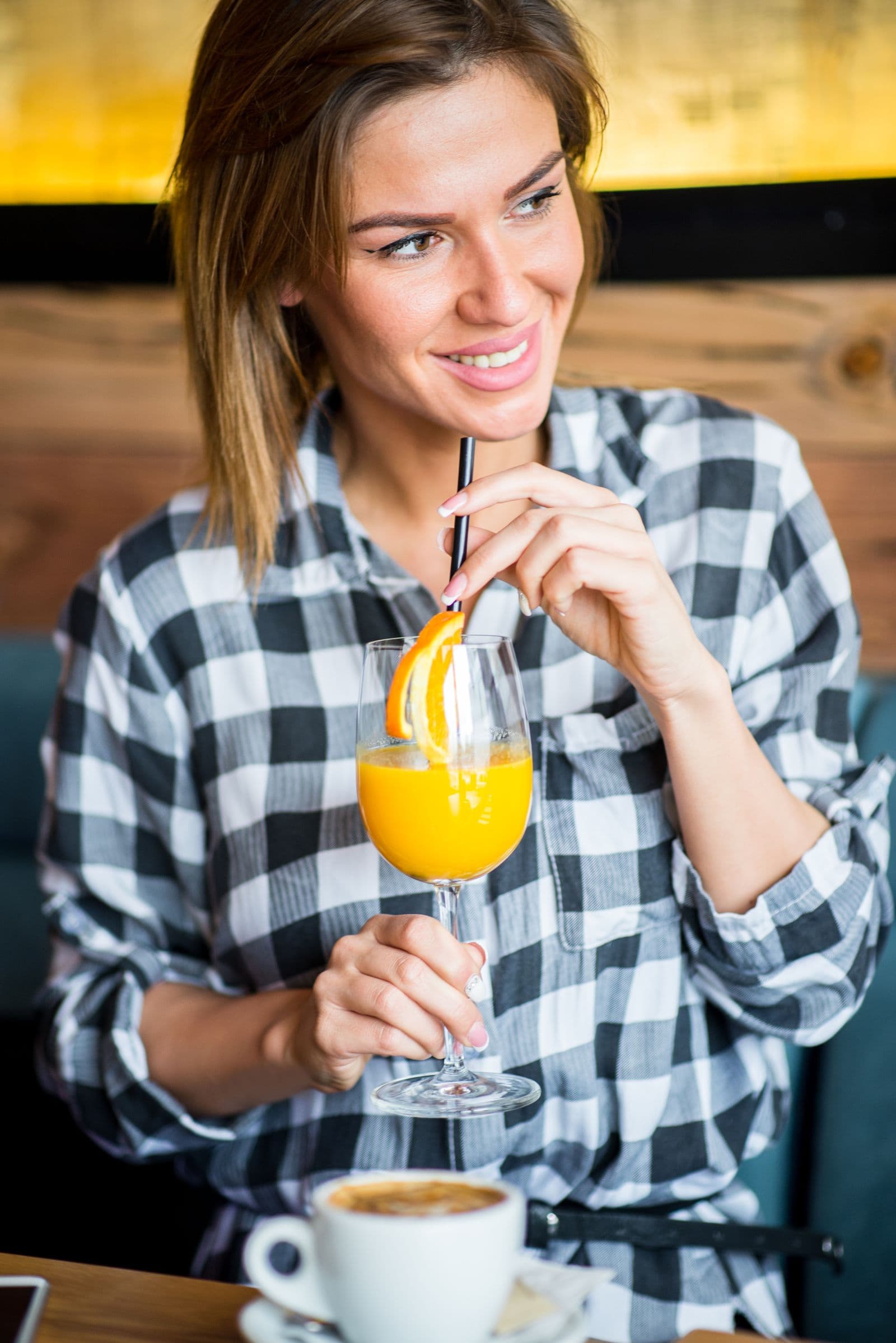 Gast mit einem Glas Orangensaft und einem Cappuccino auf dem Tisch