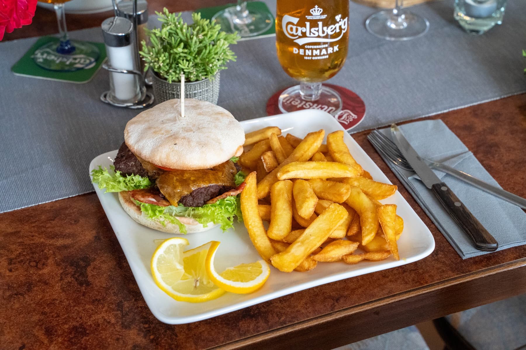 Burger mit dicken Pommes und einem Carlsberg